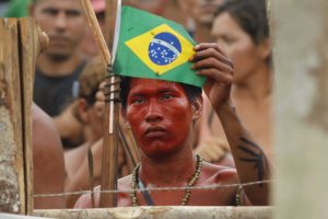 An Amazon Indian holds a Brazilian flag as police evict a group of squatters consisting of Indians and non-Indian settlers from a plot of privately-owned forest in Iranduba