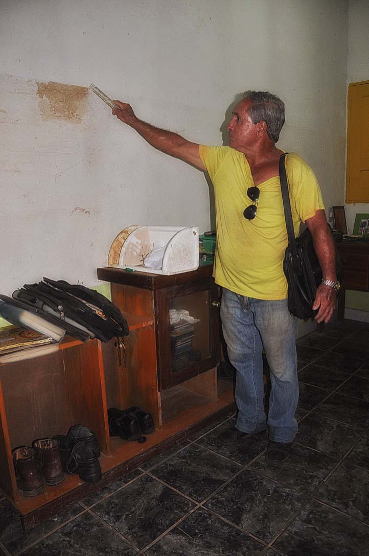 Otacílio Augusto de Oliveira aponta a marca da água em sua casa após a cheia de 2015 no Acre. Foto: Maria Emília Coelho